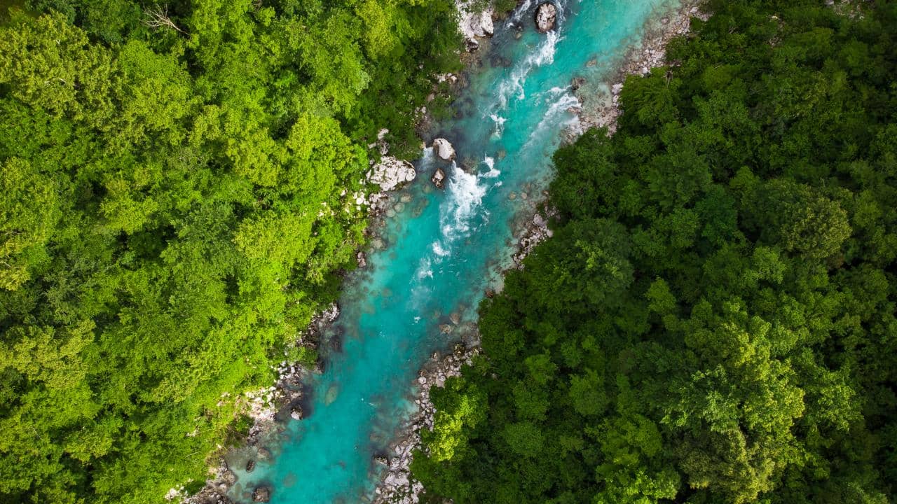 Emerald green Soca river in Slovenia, top down aerial photo.